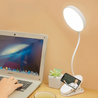 Lampe Rechargeable Tactile et Ajustable sur fond beige avec un ordinateur portable à gauche
